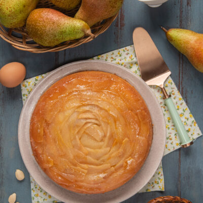 Torta rovesciata alle pere con paletta per dolci e cestino di pere