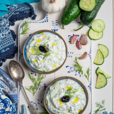 salsa tzatziki in ciotoline con olio e olive nere e cetrioli intorno