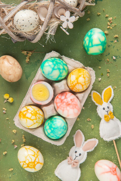 Uova marmorizzate su sfondo verde con coniglietti di Pasqua