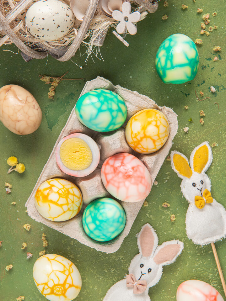 Uova marmorizzate su sfondo verde con coniglietti di Pasqua