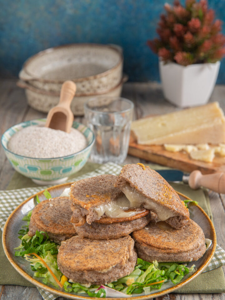 Foto chisciöi impattati su letto di insalata con casera intero e a dadini e ciotolina con farina di grano saraceno