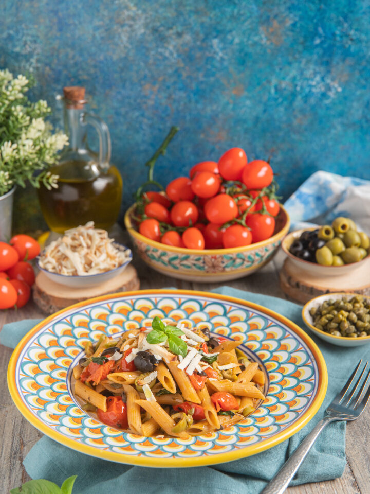 piatta da portata con pasta alla Eoliana, pomodori, olive, capperi