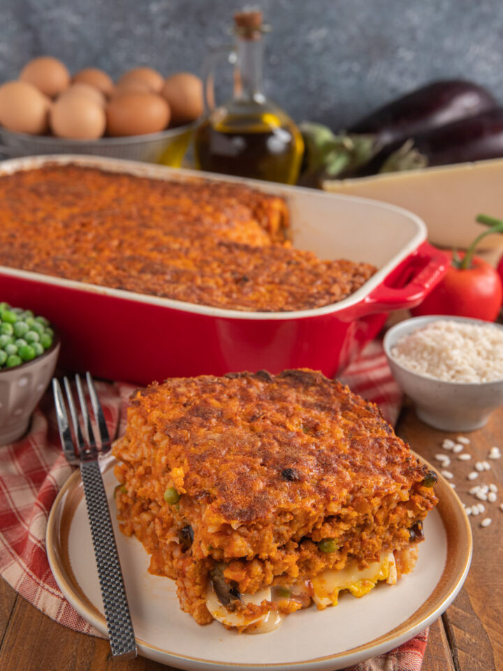 Un piatto a base di riso, tipico della cucina siciliana, che ricorda i gusti della classica parmigiana di melanzane, arricchita dalla presenza di uova, prosciutto e riso al ragù con piselli