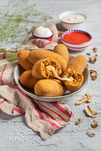 piatto con supplì al telefono fritti e supplì diviso in due con mozzarella filante