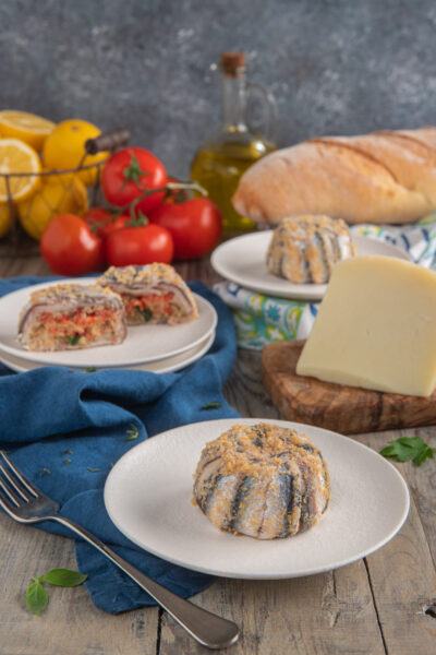 Il tortino di alici alla siciliana è un antipasto o un secondo piatto tradizionale della cucina siciliana a base di pesce, pecorino e sugo di pomodoro