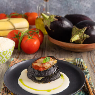 piatto con torretta di melanzane e fonduta sul fondo