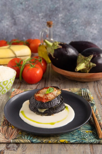piatto con torretta di melanzane e fonduta sul fondo