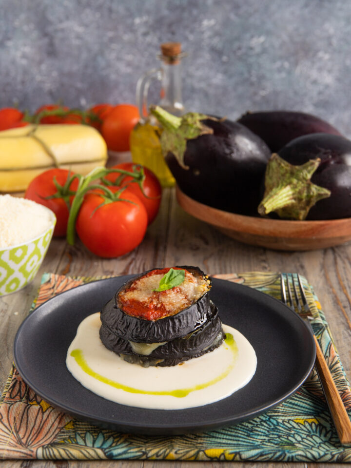 piatto con torretta di melanzane e fonduta sul fondo