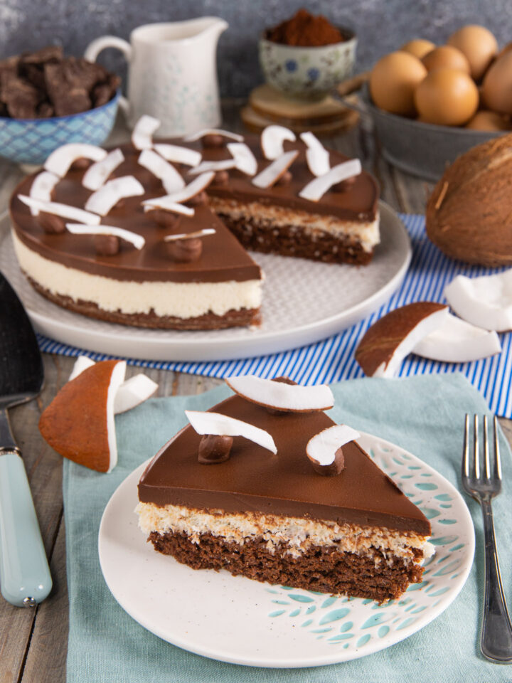 Una torta a strati composta da una base di soffice pasta biscotto al cacao, un inserto di crema di cocco e una golosa copertura al cioccolato