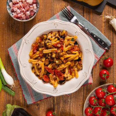 La pasta melanzane e pancetta è un primo piatto ricco di gusto che racchiude tutti gli aromi tipici della cucina mediterranea