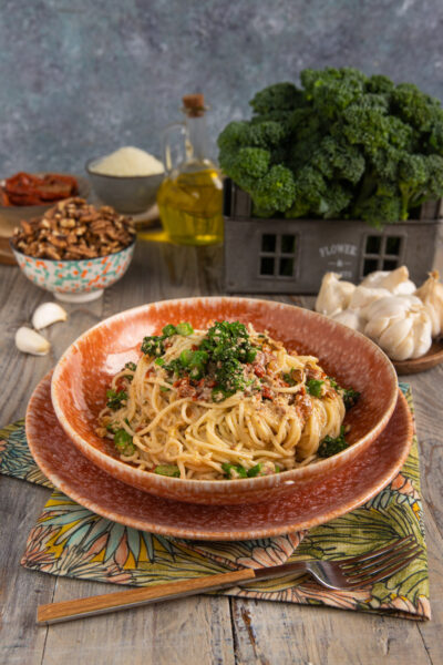 Un primo piatto di pasta fresca senza uova, in formato spaghetti, che incontra il pesto di noci, i broccoletti e i pomodori secchi