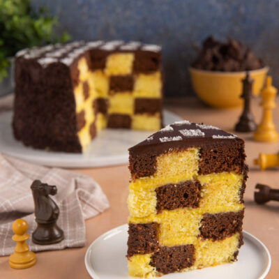 Un dolce a strati scenografico, con un interno bianco e nero, farcito di crema all'arancia e coperto da una golosa copertura di cioccolato fondente