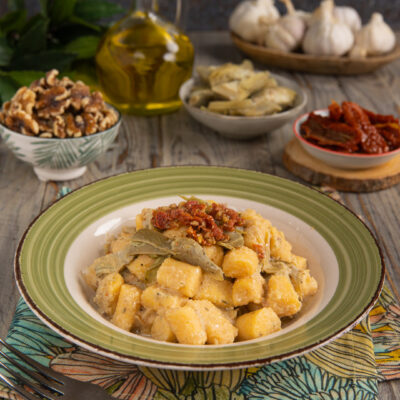 Un primo piatto in cui la polenta è protagonista ma assume la forma degli gnocchi e si accompagna a un condimento a base di carciofi e pomodori secchi
