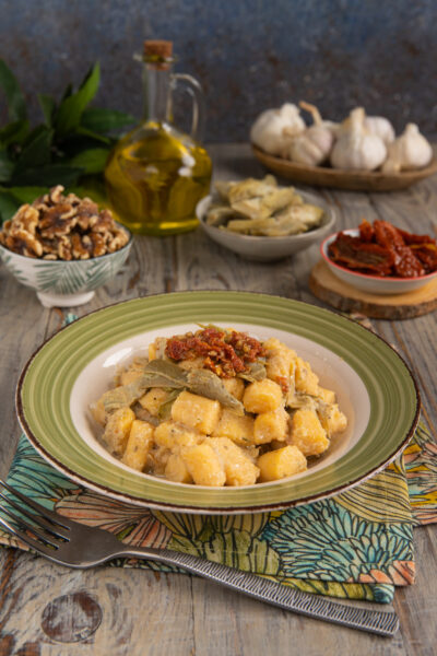 Un primo piatto in cui la polenta è protagonista ma assume la forma degli gnocchi e si accompagna a un condimento a base di carciofi e pomodori secchi
