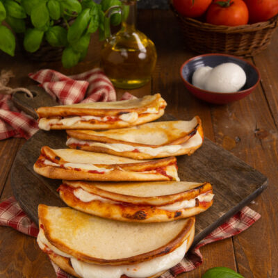 Più piccole della classica pizza e servite piegate a mezzaluna: le pizzette da passeggio sono uno street food di recente invenzione, diffuso soprattutto in sardegna, che non ha nulla da invidiare alla più celebre pizza napoletana a portafolio