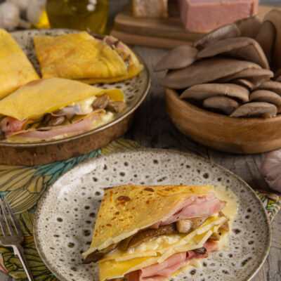 Un antipasto o piatto unico in cui la morbidezza delle crespelle avvolge un ripieno saporito a base di prosciutto e funghi, co in più il tocco scioglievole della crema di taleggio