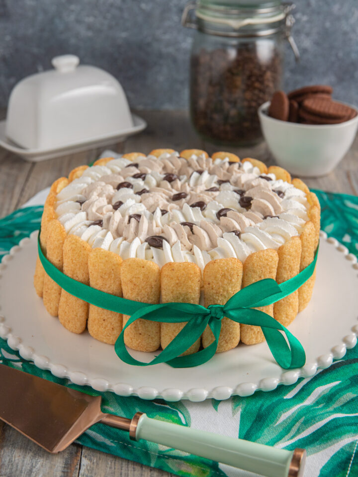 Una torta con una doppia farcitura di crema al mascarpone aromatizzata al caffè, con una decorazione esterna di biscotti