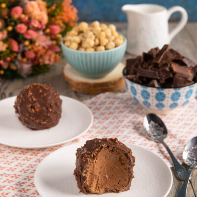 Un dolce al cucchiaio al cioccolato, con un cuore cremoso racchiuso in un guscio croccante di glassa rocher con granella di nocciole