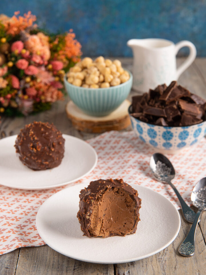 Un dolce al cucchiaio al cioccolato, con un cuore cremoso racchiuso in un guscio croccante di glassa rocher con granella di nocciole