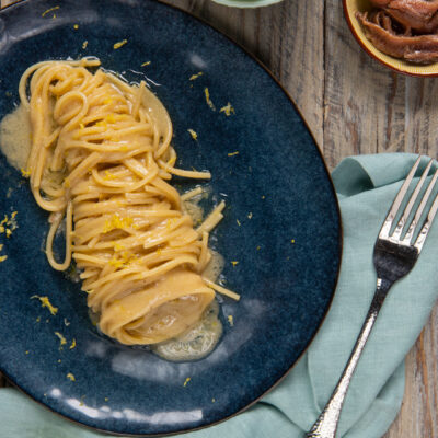 Un primo piatto di pasta condito nella maniera più semplice ma deliziosa con il burro e in più con un tocco sapido dato dalle acciughe e la nota fresca della scorza di limone