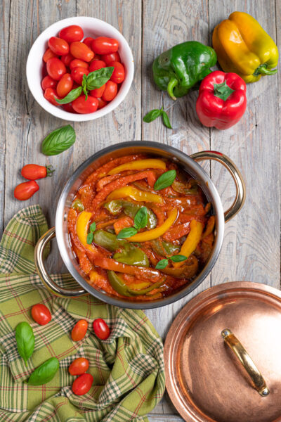 Un delizioso contorno vegetariano con i colori del sole e il profumo d'estate mediterranea, a base di peperoni, pomodori e basilico