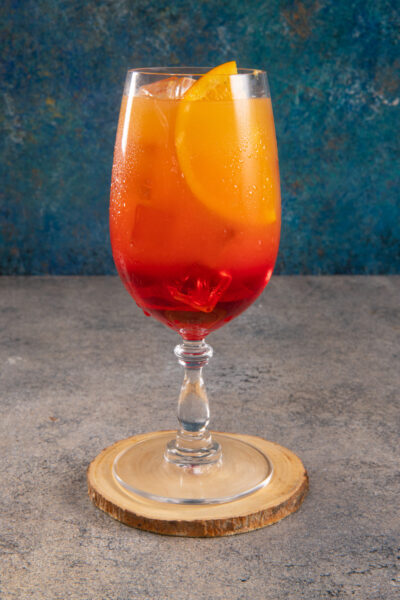 Un cocktail che ha il colore di un tramonto sulla spiaggia, dal gusto fruttato ed esotico
