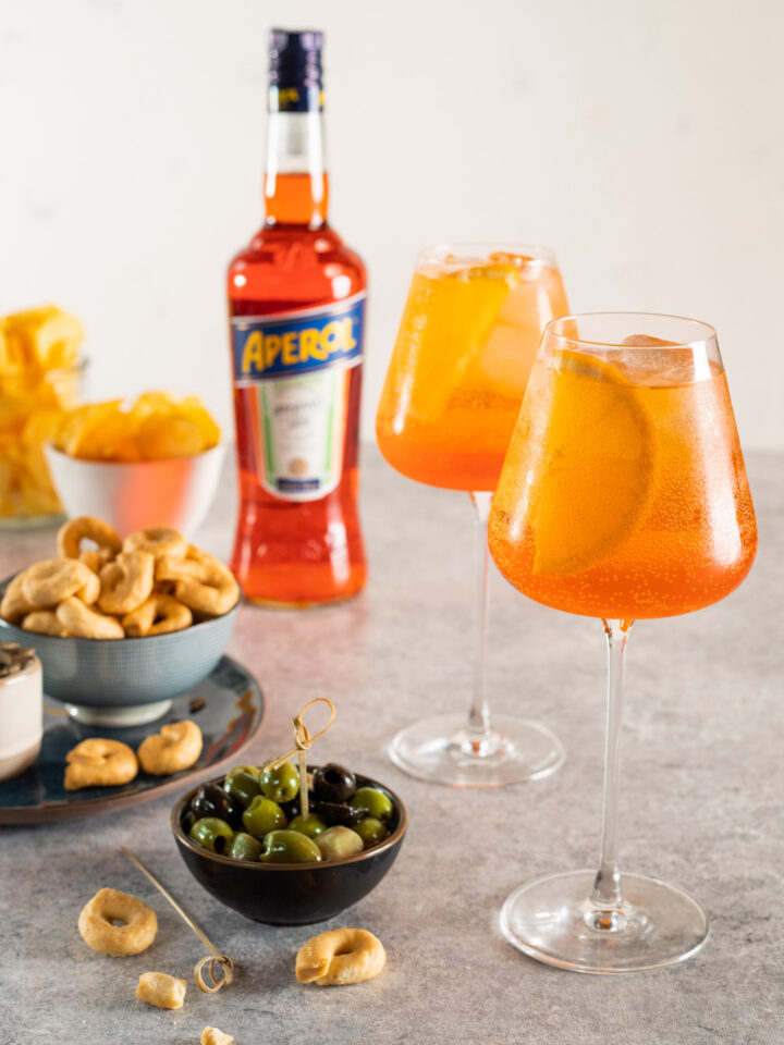 È il più classico dei drink dell'aperitivo all'italiana, una bevanda alcolica a base di Aperol, prosecco e soda, con un tocco in più dato dall'arancia