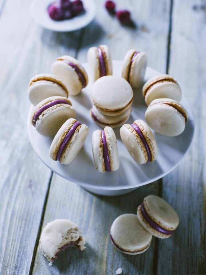 Dolcetti composti da due semisfere a base di mandorle con una farcitura di ganache al cioccolato bianco e lamponi