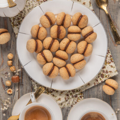 Piccoli dolcetti tipici della pasticceria piemontese, composti da due semisfere di biscotto a base di nocciole, unite come un bacio da una crema al cioccolato fondente