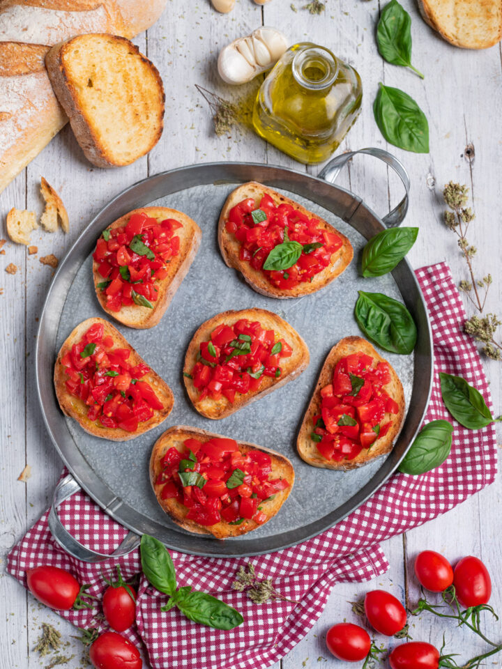 Una fetta di pane rustico, uno spicchio d'aglio, del pomodoro fresco a cubetti, olio e origano e il gioco è fatto! L'antipasto più mediterraneo è servito!