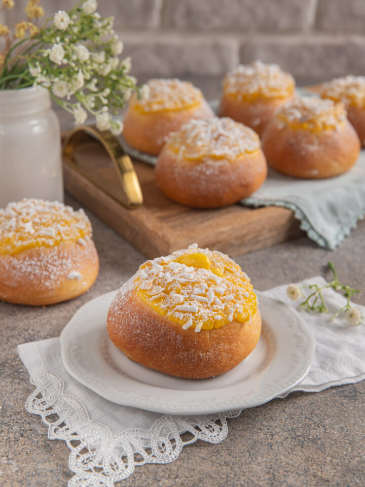 Le veneziane alla crema sono brioches lievitati e soffici con una copertura di crema pasticcera profumata agli agrumi, lamelle di mandorle e zucchero