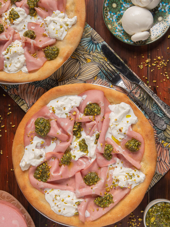 Una pizza gourmet senza pomodoro ma con una golosa farcitura a base di mortadella, burrata e pesto di pistacchi. Ideale per uno spuntino goloso, una merenda al sacco o da servire sulla tavola dell'aperitivo