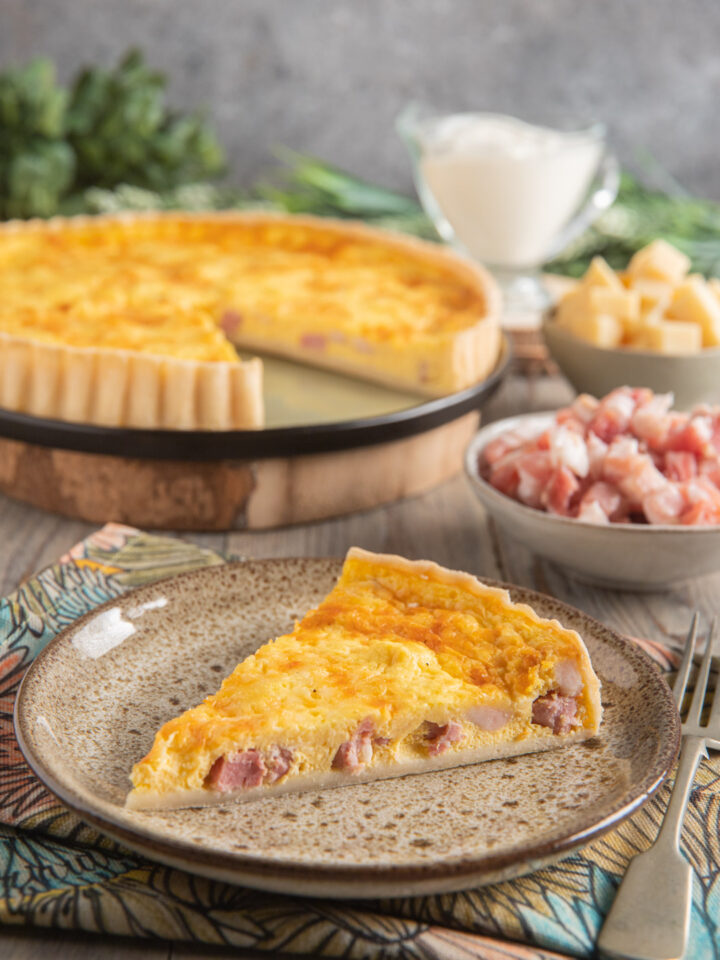 Una torta salata tipica della cucina, composta da un guscio di pasta brisée che racchiude un ripieno a base di panna, pancetta e formaggio