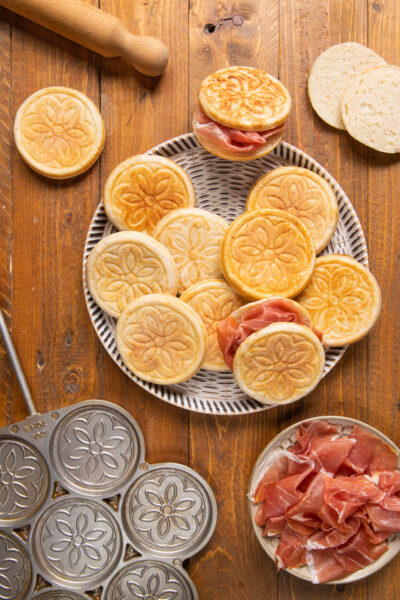 Un antipasto o piatto unico, composto da piccoli dischi di impasto lievitato, cotto sul fuoco e farcito con salumi e formaggi a scelta