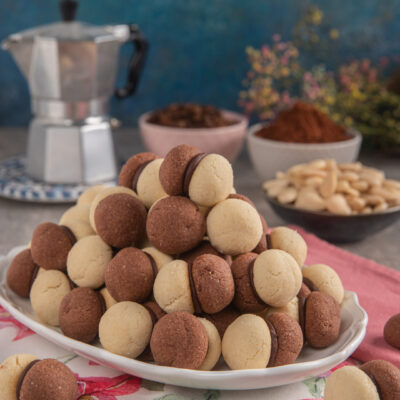 Friabili biscottini composti da due semisfere di pasta frolla alle mandorle aromatizzate alla vaniglia e al cacao e tenute insieme da una ganache al cioccolato e caffè