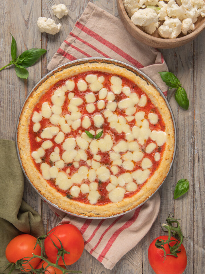 Una pizza margherita a tutti gli effetti con tanto di pomodoro, mozzarella, basilico e cornicione, ma in cui l'impasto classico di acqua e farina è sostituito da una base di cavolfiore!