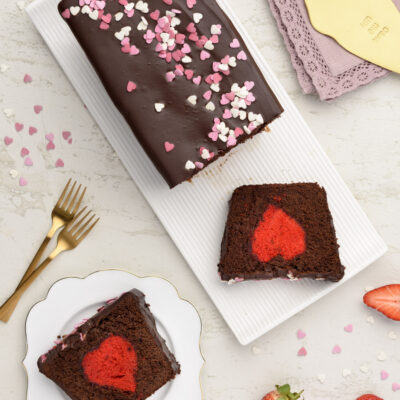 Una torta al cioccolato che ha l'aspetto di un classico plumcake coperto da una deliziosa ganache, ma nasconde un cuore romantico rosso fuoco!