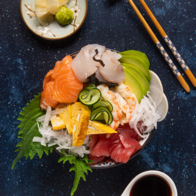La chirashi è un sushi in ciotola, con una base di riso e tanti ingredienti di colori, forme e sapori diversi, a scelta tra pesce, gamberi, verdure e frutti
