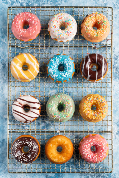 I donuts sono ciambelle lievitate, fritte o cotte al forno, ricoperte di glassa all'acqua colorata e decorate con zuccherini e codette variopinte per un'esplosione di allegria fin dalla colazione!