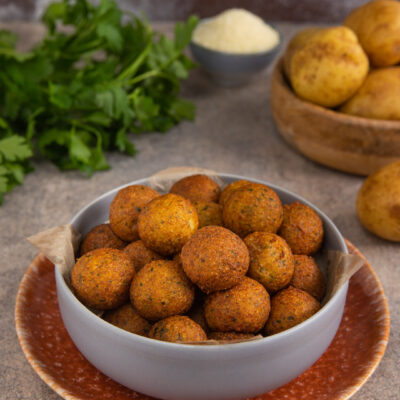 Piccole sfere di patate fritte, dorate e croccanti fuori, e con un filante cuore di mozzarella