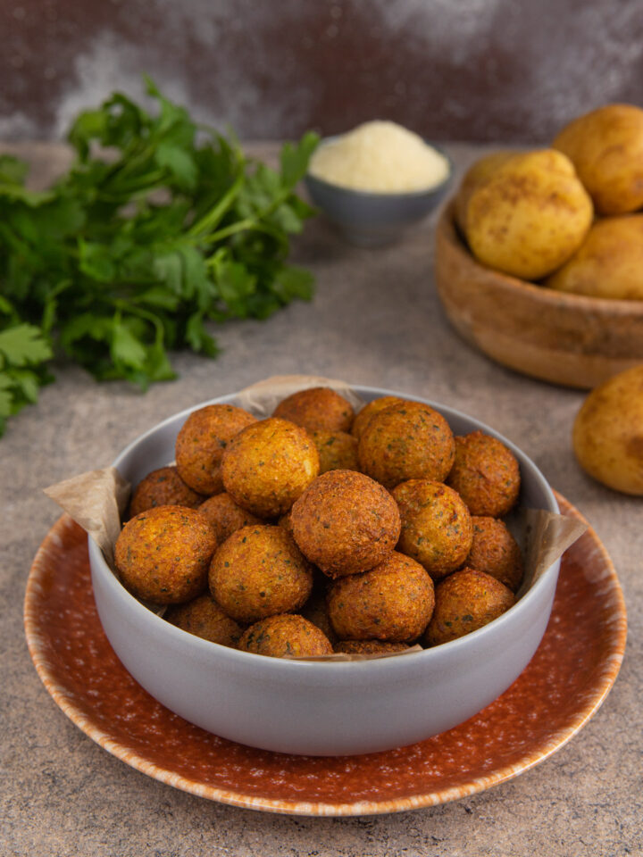 Piccole sfere di patate fritte, dorate e croccanti fuori, e con un filante cuore di mozzarella