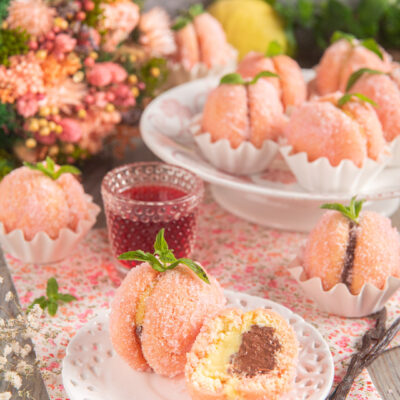 Due cupole di morbido biscotto coperte di zucchero e aromatizzate all'Alchermes con una doppia farcitura alla crema pasticcera in versione classica e al cioccolato