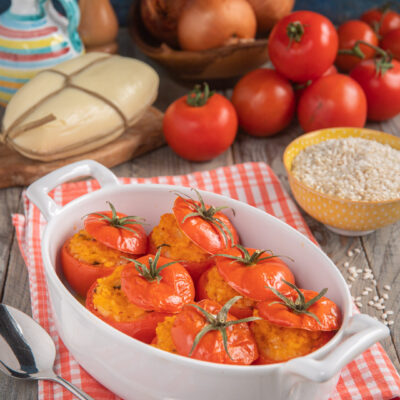 Una ricetta in cui il pomodoro viene usato come contenitore per un risotto rosso arricchito con provola e profumato al basilico