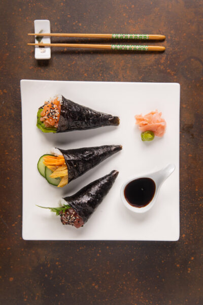 I temaki sono un tipo di sushi a forma di cono di alga Nori ripieno di riso, pesce e verdure, fritttata giapponese, wasabi e semi di sesamo