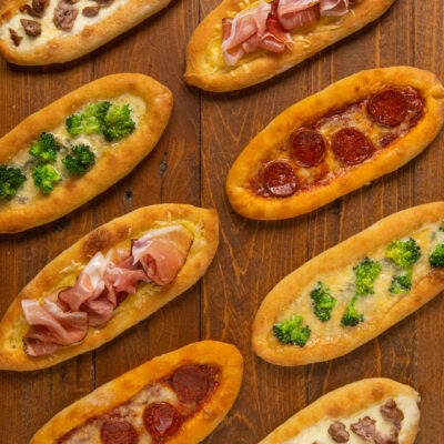 Il classico impasto della pizza composto in forma di barchette e farcito con vari ingredienti (pomodoro, mozzarella e salamino, Emmental e speck, gorgonzola e broccoli, stracchino e salsiccia)