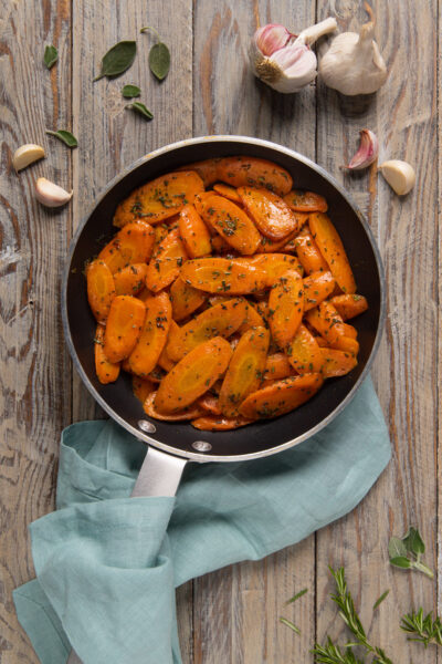 Un contorno semplice e colorato, a base di carote saltate in padella e profumate con aglio, timo, salvia e rosmarino