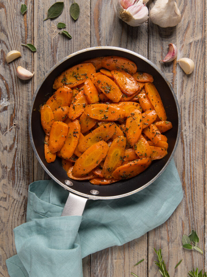 Un contorno semplice e colorato, a base di carote saltate in padella e profumate con aglio, timo, salvia e rosmarino