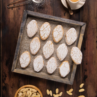 I Ricciarelli sono dolcetti tipici della pasticceria toscana a base. di pasta di mandorla e arancia candita coperti di zucchero a velo