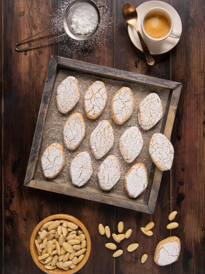 I Ricciarelli sono dolcetti tipici della pasticceria toscana a base. di pasta di mandorla e arancia candita coperti di zucchero a velo