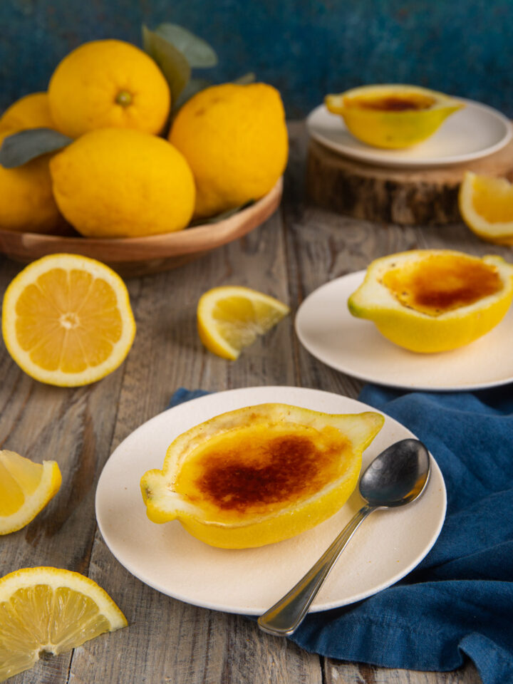 Un dolce al cucchiaio fresco e scenografico, che si prepara come una crema pasticcera profumata al limone e si serve nella scorza di mezzo agrume con una leggera crosticina caramellizzata in superficie.